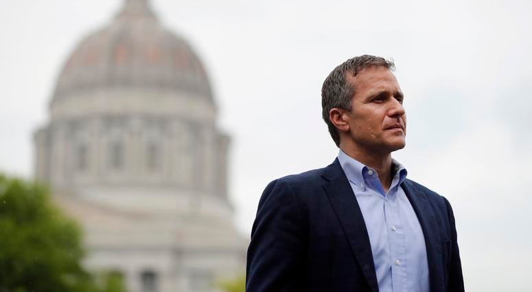 Missouri Gov. Eric Greitens stands off to the side before stepping up to the podium to deliver remarks to a small group of supporters near the capitol announcing the release of funds for the state's biodiesel program in Jefferson City, Mo.